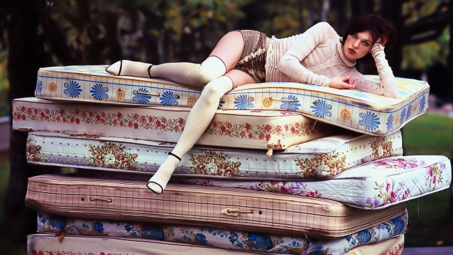 Обои картинки фото девушки, milla jovovich, шатенка, свитер, шорты, чулки, матрасы