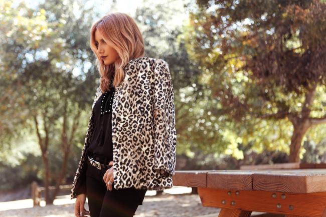 Обои картинки фото девушки, ashley tisdale, блондинка, туника, жакет, стол, деревья