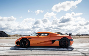 Картинка автомобили koenigsegg оранжевый ccxr облака небо площадка