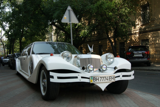 Обои картинки фото автомобили, выставки, уличные, фото, дома, деревья, лимузин, улица, дорожный, знак