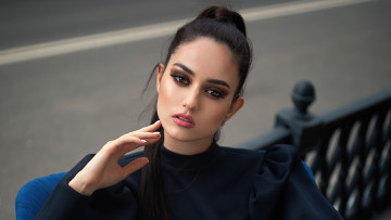 Картинка девушки -+брюнетки +шатенки положа руку на лицо сидя стуле черное платье