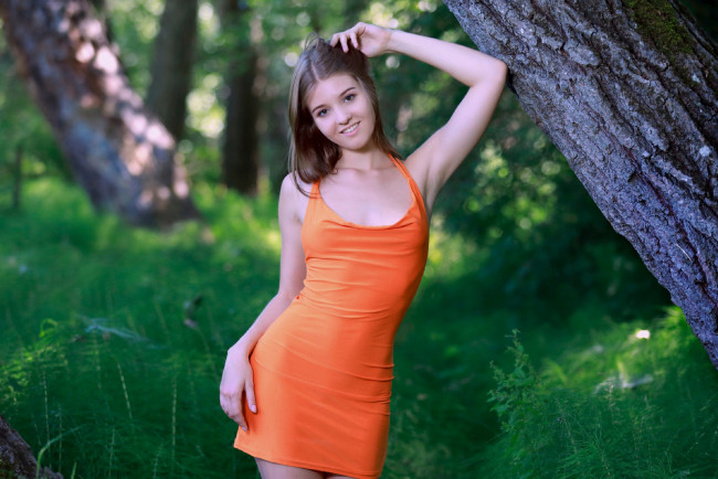 Обои картинки фото девушки, carolina kris, ствол, поза, платье, мини, улыбка