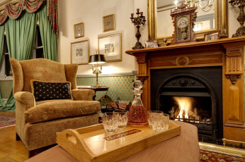 Картинка интерьер камины бутылка кресло камин гостиная часы огонь виски