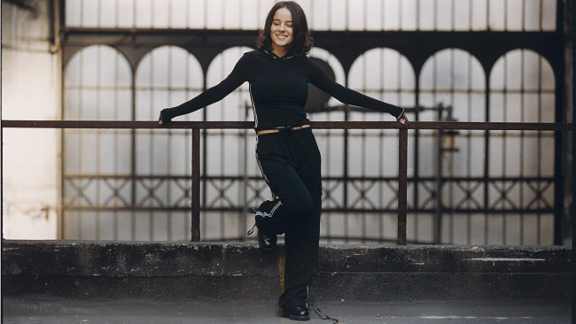 Обои картинки фото музыка, alizee, французская, певица, ализе, жакоте, брюнетка, темные, глаза, тренировка, черные, наряды, брюки, женщины, стоя, улыбается, знаменитость