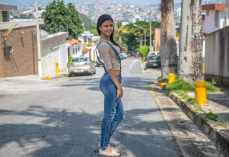 обоя denisse gomez, девушки, взгляд, макияж, улица, джинсы, комбинезон, denisse, gomez, поза, брюнетка, красотка, девушка