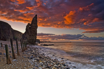 Картинка природа побережье океан пляж галька скалы тучи зарево