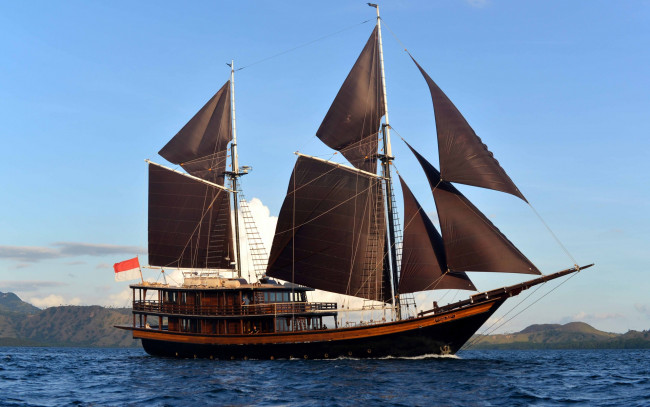 Обои картинки фото корабли, парусники, водоем, флаг, побережье, облака