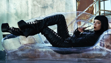 Картинка девушки anya+taylor+joy актриса брюнетка куртка штаны каблуки диван очки