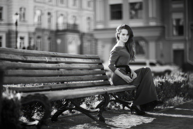 Обои картинки фото девушки, - черно-белые, девушка, одетая, сидит, скамейка, взгляд, на, зрителя, черно, белое