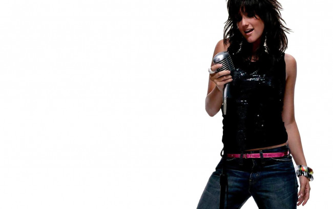 Обои картинки фото девушки, ashlee simpson, браслеты, джинсы, микрофон, топ, брюнетка