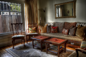 Картинка интерьер гостиная книги диван столики подушки зеркало