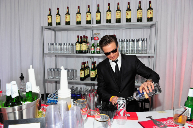 Обои картинки фото jeremy, renner, мужчины, бар, актер, очки, костюм, напитки, бутылки