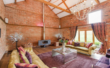 Картинка интерьер гостиная диваны декор столик камин ковер цветы кладка кирпич оригинальный дом дизайн лампа