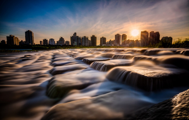 Обои картинки фото города, - пейзажи, небо, солнце, закат, город, дома, камни, вода