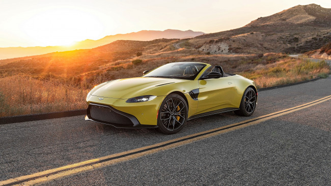 Обои картинки фото aston martin vantage roadster, автомобили, aston martin, желтый, кабриолет, горы, дорога