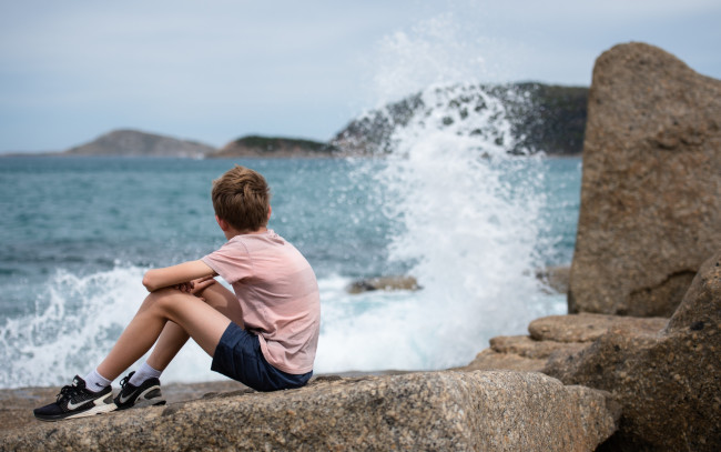 Обои картинки фото разное, дети, мальчик, камни, берег, море, брызги
