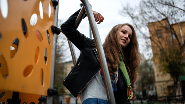 Обои картинки фото девушки, ксана станкевич, шатенка, куртка, косуха, шарф, футболка, площадка, двор, дома