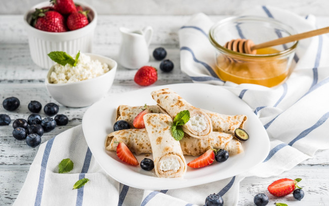 Обои картинки фото еда, блины,  оладьи, ягоды, голубика, мед, рулеты, творог, клубника