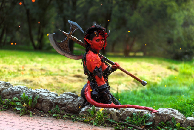 Обои картинки фото svizee, девушки, анастасия волкова , образ, косплей, наряд, костюм, хвост, рога, демонесса, топор, трава, поляна, лес, искры