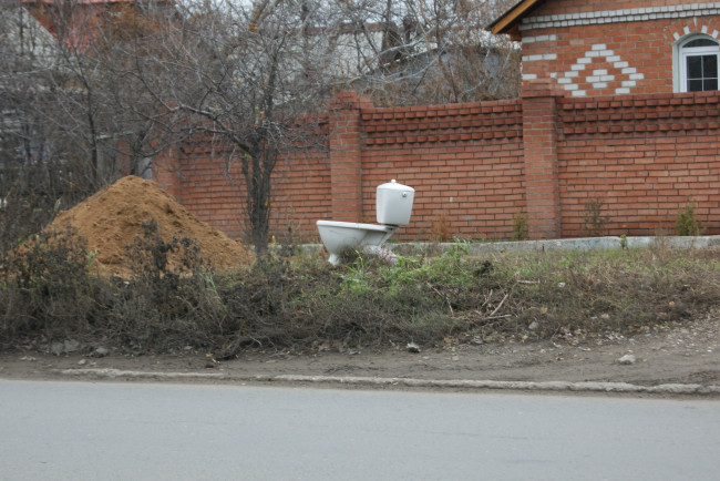 Обои картинки фото юмор, приколы, куча, песка, дорога, забор, дом, унитаз