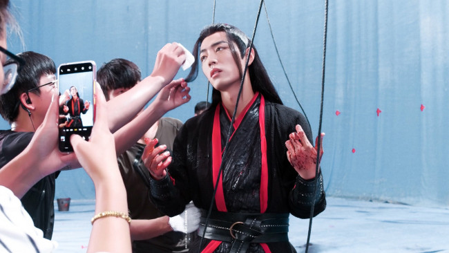 Обои картинки фото разное, знаменитости, актер, костюм, кровь, съемки, веревки, сяо, чжань, телефон, люди