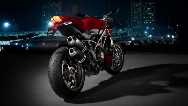 Обои картинки фото мотоциклы, ducati, дукати, площадка, ночь, огни, дома, здания