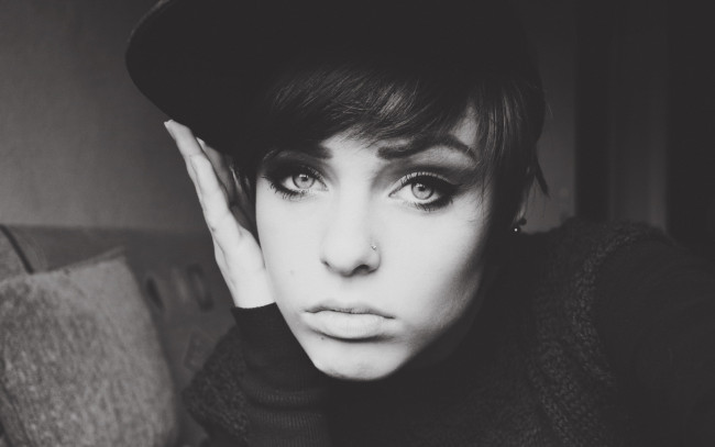 Обои картинки фото девушки, lana branishti, черно-белая, лицо, пирсинг, кепка, диван, свитер