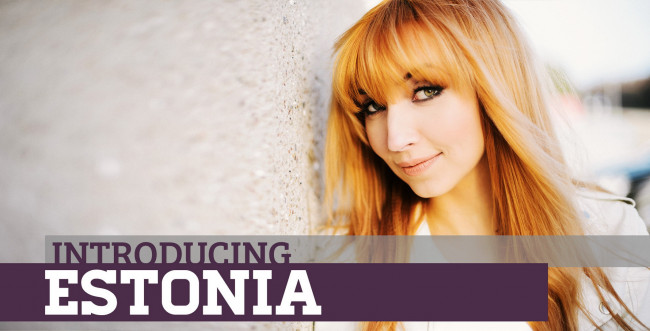 Обои картинки фото музыка, евровидение, tanja, эстония, певица, рыжеволосая, улица, улыбка, стена, куртка, взгляд, надпись