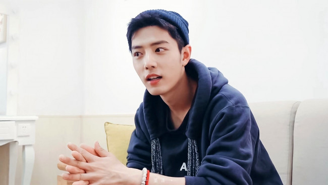 Обои картинки фото мужчины, xiao zhan, актер, шапка, толстовка, диван