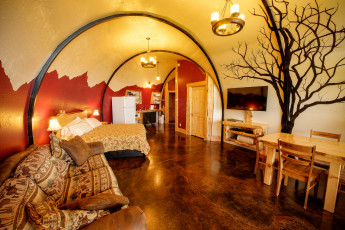 Картинка интерьер спальня диван круглый потолок кровать стены люстры стол свет комната