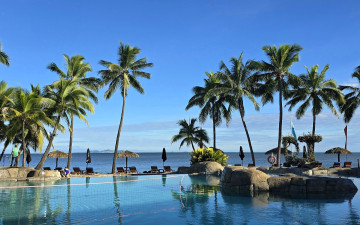 обоя природа, тропики, небо, море, бассейн, камни, зонтики, пальмы