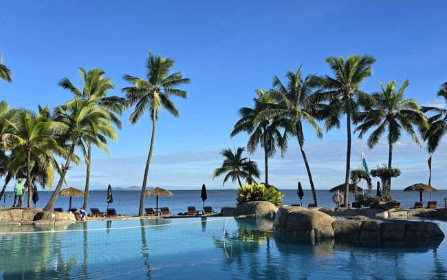 Обои картинки фото природа, тропики, небо, море, бассейн, камни, зонтики, пальмы