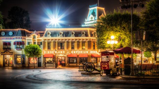 Обои картинки фото города, диснейленд, здания, ночь, киоски, площадь