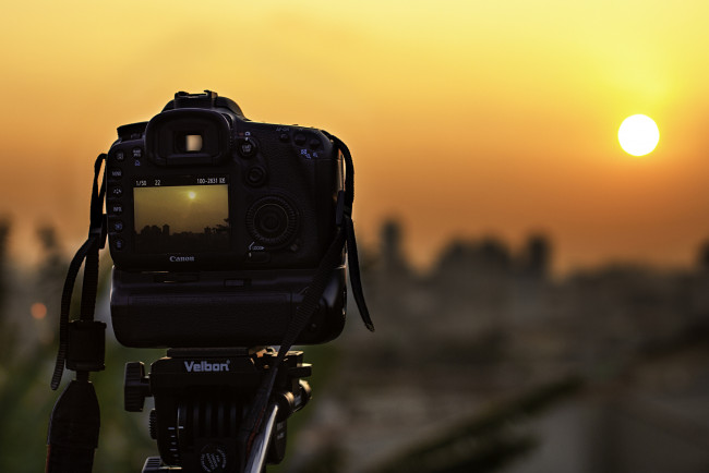 Обои картинки фото бренды, canon, камера, кэнон, подставка, фотоаппарат, солнце, съемка, закат