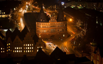 Картинка города -+огни+ночного+города городской вид архитектура улица ночь огни уличный фонарь старое здание башня германия световые дорожки длинная выдержка с воздуха крыши автомобиль трафик деревья оранжевый любек
