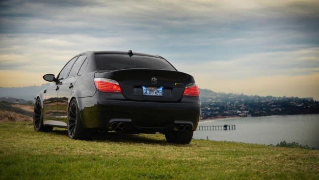 Обои картинки фото автомобили, bmw, бмв, e60, небо, m5, задок, фар, свет, тучи, чёрный, black