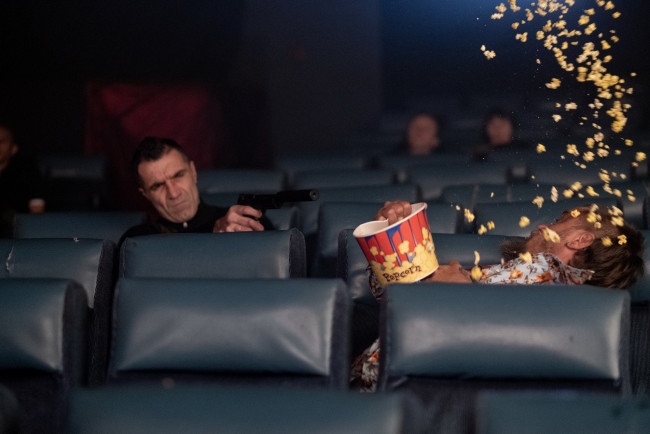 Обои картинки фото кино фильмы, die in a gunfight, киллер, пистолет, зал, жертва, попкорн