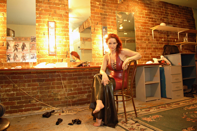 Обои картинки фото Bianca Beauchamp, девушки, стул, зеркало, лампочки, сумка, полка, ковер, кирпич, кожа, стол, красотка