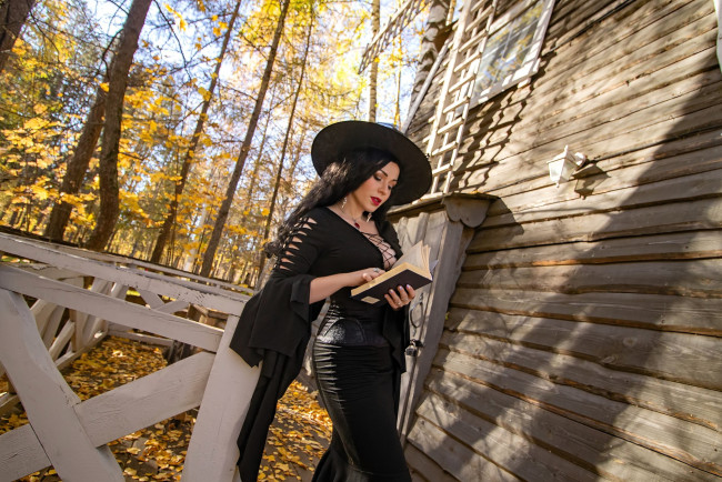 Обои картинки фото девушки, юлия огородникова, образ, косплей, наряд, костюм, ведьма, шляпа, книга, платье, дом, деревья, осень, лес