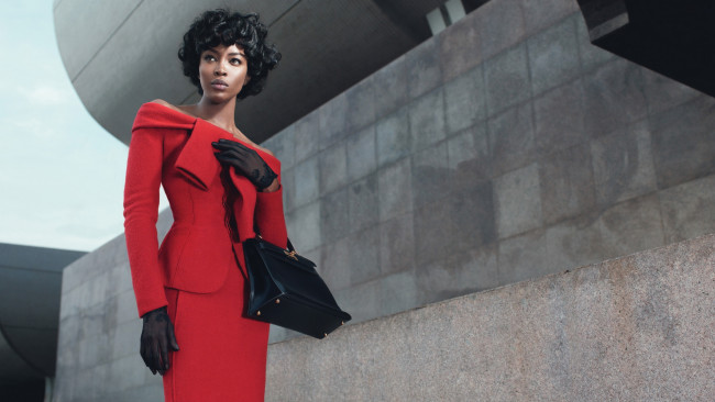 Обои картинки фото девушки, naomi campbell, костюм, перчатки, сумочка