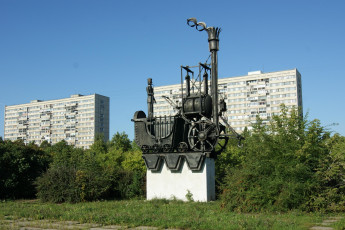 Картинка города памятники скульптуры арт объекты статуя паровоза деревья трава дома небо тольятти