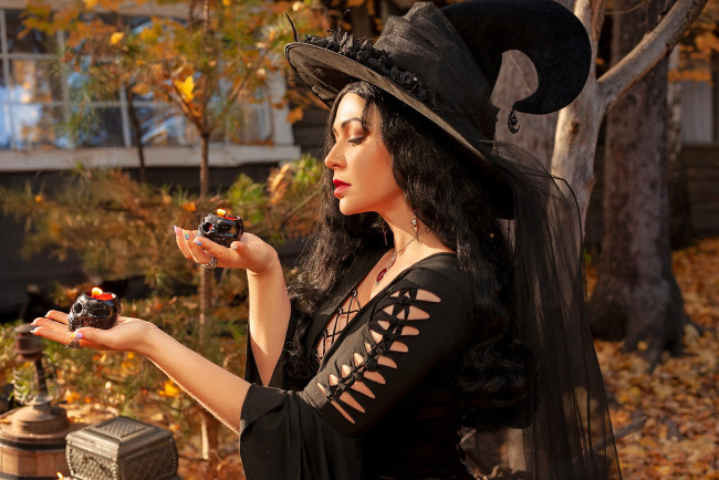 Обои картинки фото девушки, юлия огородникова, образ, косплей, костюм, наряд, ведьма, шляпа, платье, свечи, черепа, осень, листья, деревья, дом, двор, шкатулка